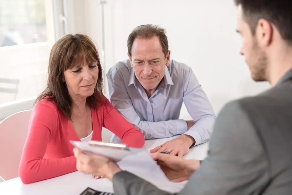 Couple at a lawyers office, looking at documents.