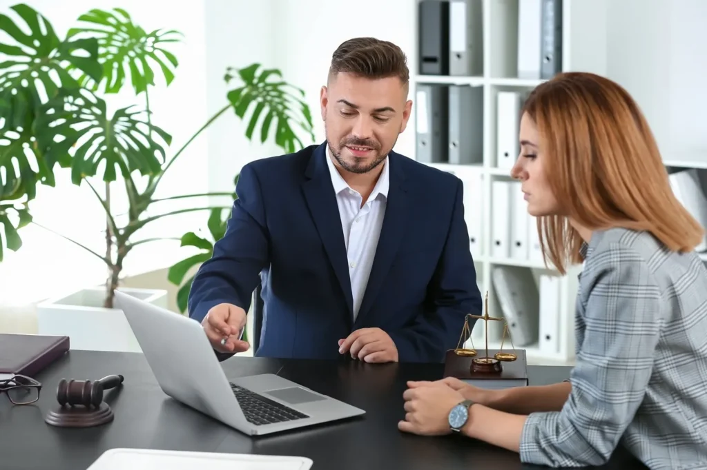 Attorney meeting with client, pointing to laptop screen.