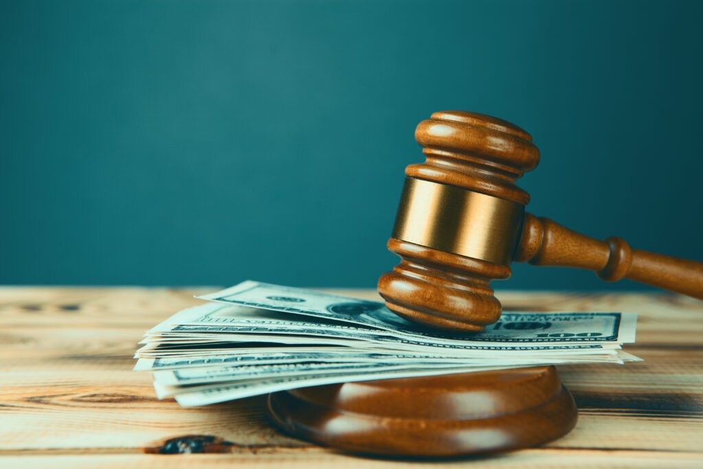 A stack of money under wooden gavel.