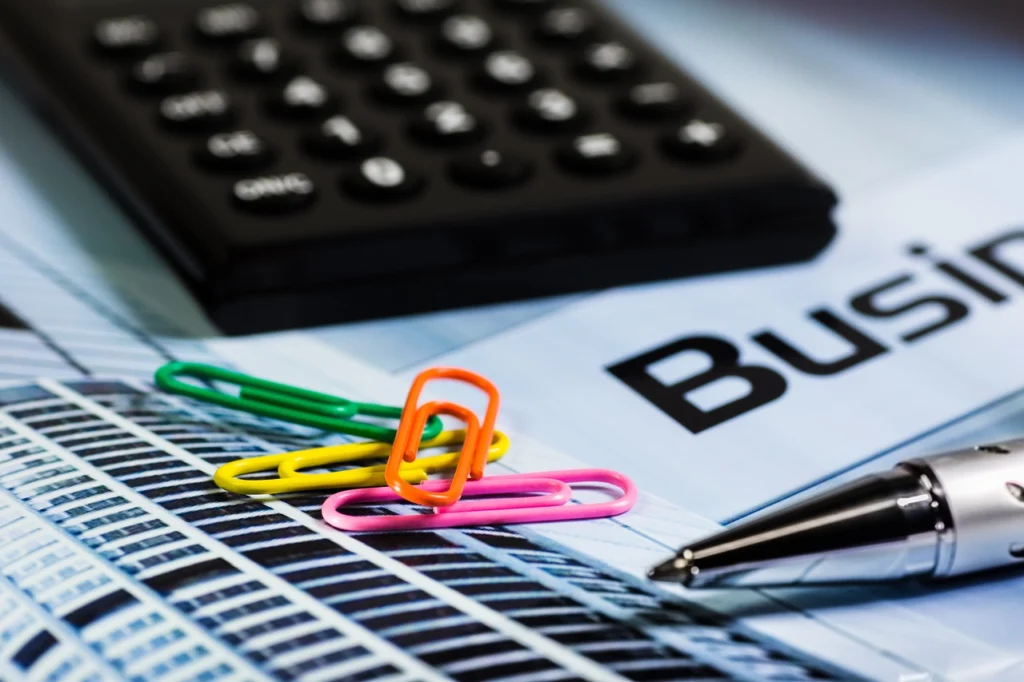 Paperclip and calculator on a desk with documents.